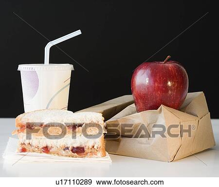 Stock Photo - Sandwich, apple and drink next to paper bag. Fotosearch