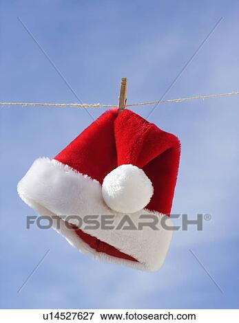 Santa Claus hat hanging on clothesline View Large Photo Image Stock Photo - Santa Claus hat hanging on clothesline. Fotosearch