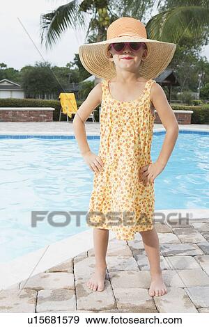 Stock Photo - Sassy girl standing at edge of swimming pool. Fotosearch