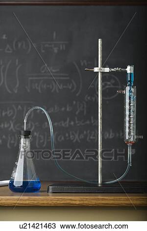 Stock Image - Science experiment in front of blackboard. Fotosearch