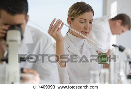 Stock Image - Scientists experimenting in pharmaceutical laboratory. Fotosearch