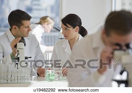 Stock Image - Scientists working in pharmaceutical laboratory. Fotosearch