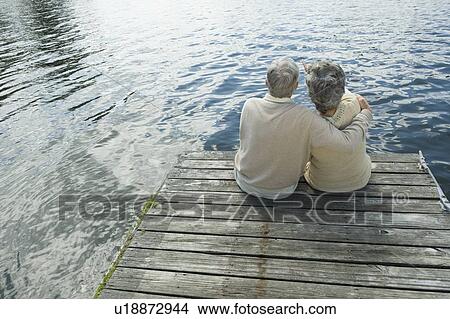 Picture - Senior couple hugging on dock. Fotosearch