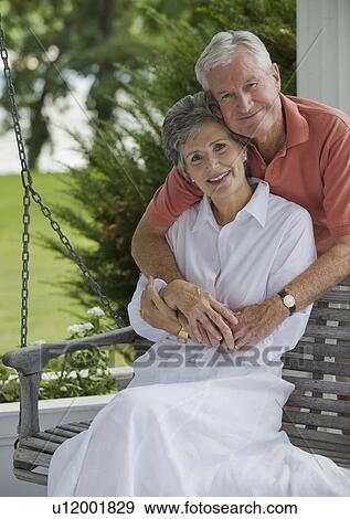 Stock Photo - Senior couple sitting on porch swing. Fotosearch