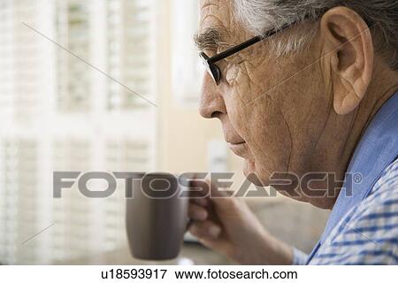 Stock Photo - Senior man holding coffee mug. Fotosearch