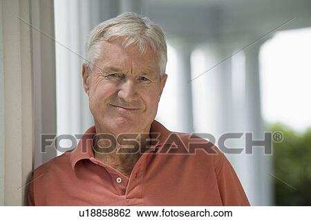 Stock Image - Senior man leaning against column. Fotosearch