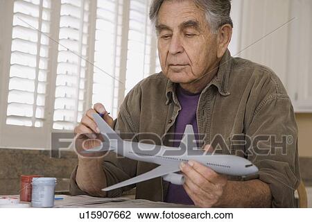 Senior man painting airplane model View Large Photo Image Stock Image - Senior man painting airplane model. Fotosearch