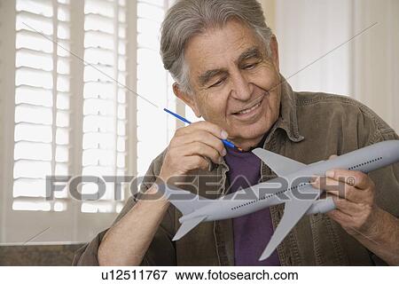 Senior man painting airplane model View Large Photo Image Stock Photo - Senior man painting airplane model. Fotosearch