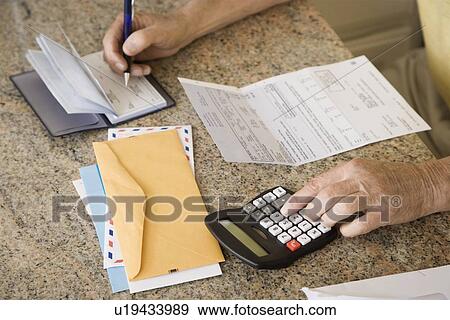 Stock Photo - Senior man paying bills. Fotosearch