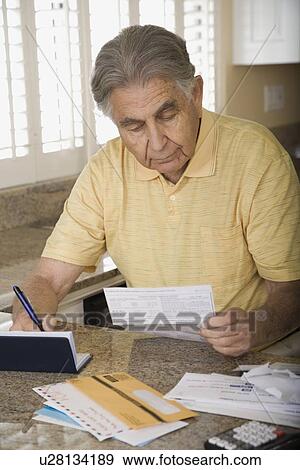 Stock Photo - Senior man paying bills. Fotosearch