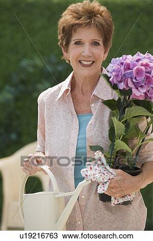 Stock Image - Senior woman gardening. Fotosearch