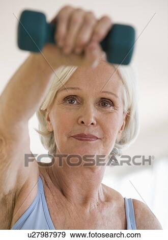 Senior woman lifting hand weight View Large Photo Image Stock Photo - Senior woman lifting hand weight. Fotosearch