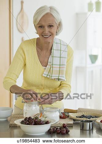 Stock Image - Senior woman making pies. Fotosearch
