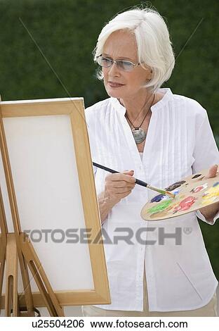 Stock Photograph - Senior woman painting. Fotosearch