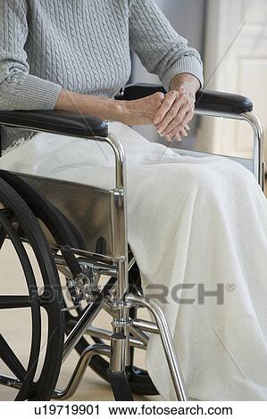 Stock Image - Senior woman sitting in wheelchair. Fotosearch