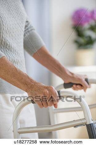 Stock Photo - Senior woman using walker. Fotosearch