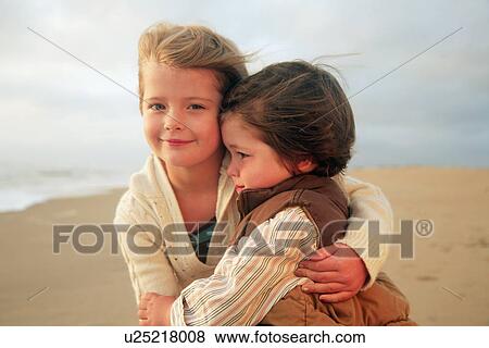 Sister and brother hugging at beach View Large Photo Image Stock Photo - Sister and brother hugging at beach. Fotosearch