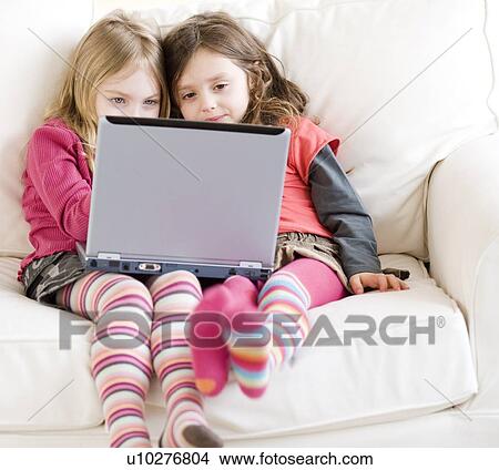 Sisters looking at laptop View Large Photo Image Picture - Sisters looking at laptop. Fotosearch
