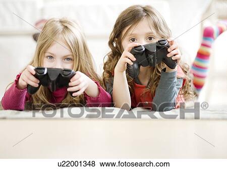 Sisters playing videogame View Large Photo Image Stock Photo - Sisters playing videogame. Fotosearch