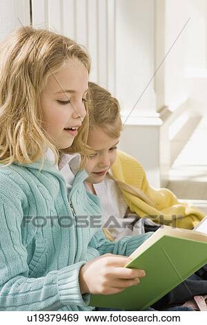 Stock Photo - Sisters reading on porch. Fotosearch