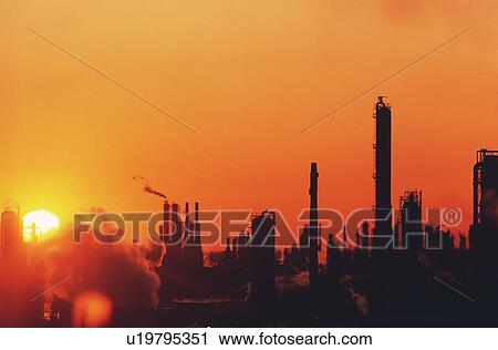 Stock Image - Sun setting on oil refinery in Baytown, Texas. Fotosearch