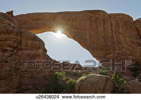 Picture - Sun shining behind South Window Arch in Arches National Park, Utah. Fotosearch