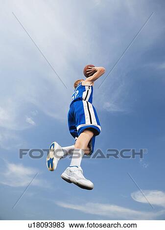 Teenage basketball player in mid-air shooting basketball View Large Photo Image Stock Image - Teenage basketball player in mid-air shooting basketball. Fotosearch