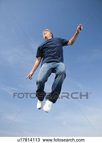 Teenage boy in mid-air View Large Photo Image Stock Image - Teenage boy in mid-air. Fotosearch