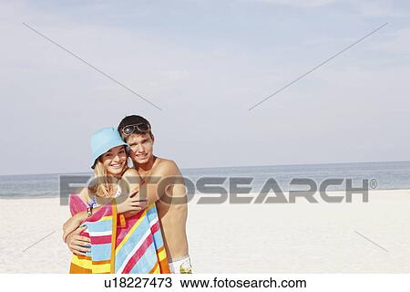 Stock Image - Teenage couple hugging on beach. Fotosearch