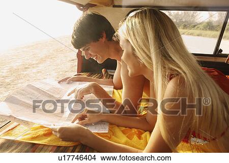 Picture - Teenage couple relaxing in van on beach. Fotosearch