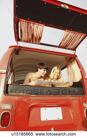 Stock Photography - Teenage couple relaxing in van on beach. Fotosearch