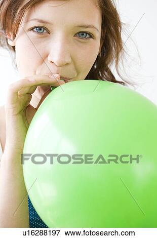 Teenage girl blowing up balloon View Large Photo Image Stock Photo - Teenage girl blowing up balloon. Fotosearch
