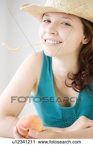 Stock Image - Teenage girl chewing on wheat stalk. Fotosearch