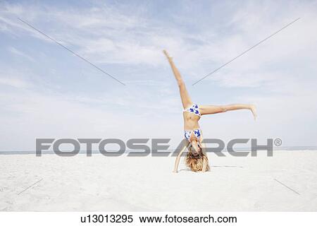 Teenage girl doing cartwheel in beach View Large Photo Image Stock Photography - Teenage girl doing cartwheel in beach. Fotosearch
