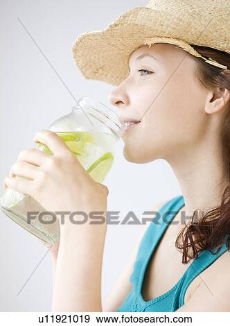 Teenage girl drinking refreshing lime water View Large Photo Image Stock Photo - Teenage girl drinking refreshing lime water. Fotosearch