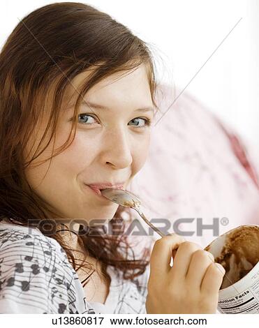 Stock Photo - Teenage girl eating from ice cream carton. Fotosearch