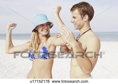 Stock Photo - Teenage girl flexing muscles for boyfriend. Fotosearch