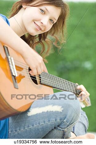 Stock Photograph - Teenage girl playing guitar. Fotosearch
