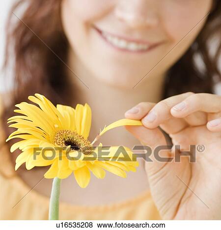 Stock Photo - Teenage girl plucking flower petal. Fotosearch