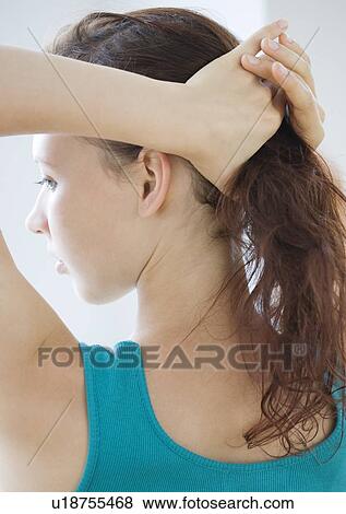 Stock Photo - Teenage girl pulling hair into ponytail. Fotosearch