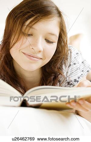 Teenage girl reading book on bed View Large Photo Image Stock Photo - Teenage girl reading book on bed. Fotosearch