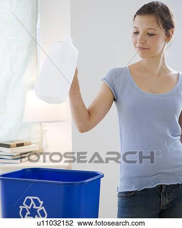 Stock Image - Teenage girl recycling milk jug. Fotosearch
