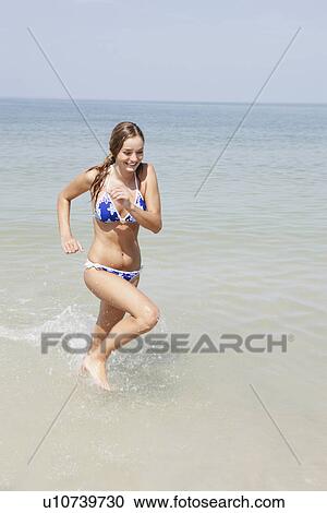 Teenage girl running in ocean View Large Photo Image Stock Image - Teenage girl running in ocean. Fotosearch
