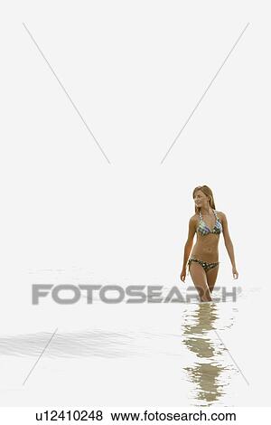 Stock Photo - Teenage girl wading in ocean. Fotosearch