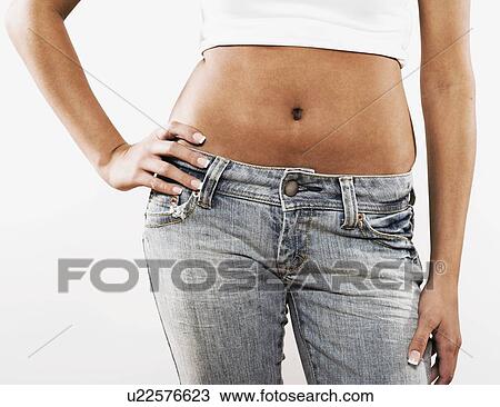 Stock Image - Teenage girl with bare midsection and hand on hip. Fotosearch