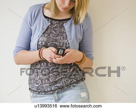 Stock Photograph - Teenaged girl dialing cell phone. Fotosearch