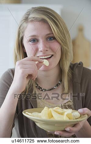 Teenaged girl eating potato chips View Large Photo Image Stock Photography - Teenaged girl eating potato chips. Fotosearch
