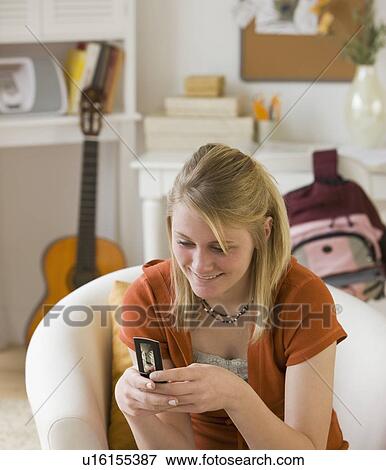 Teenaged girl looking at cell phone View Large Photo Image Stock Photo - Teenaged girl looking at cell phone. Fotosearch
