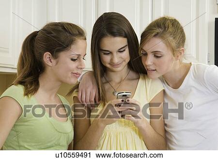 Teenaged girls looking at cell phone View Large Photo Image Stock Image - Teenaged girls looking at cell phone. Fotosearch