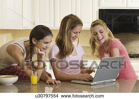 Picture - Teenaged girls looking at laptop. Fotosearch